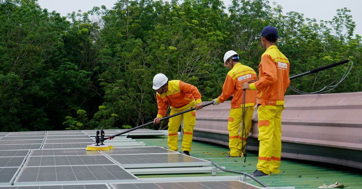 Technicians cleaning and servicing rooftop solar panels
